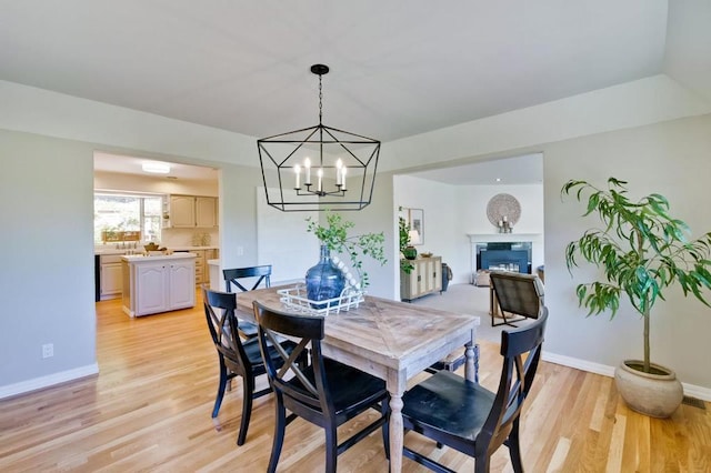 dining area with an inviting chandelier and light hardwood / wood-style floors