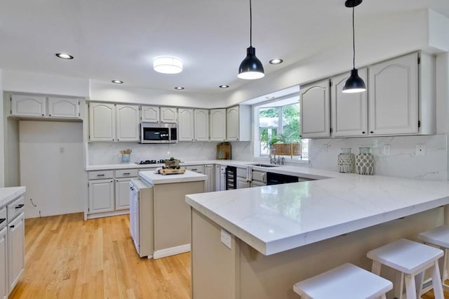 kitchen featuring light stone countertops, a center island, pendant lighting, and wine cooler