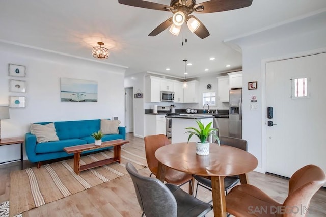 dining area with light hardwood / wood-style flooring and ceiling fan