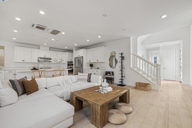 living room with sink and light wood-type flooring