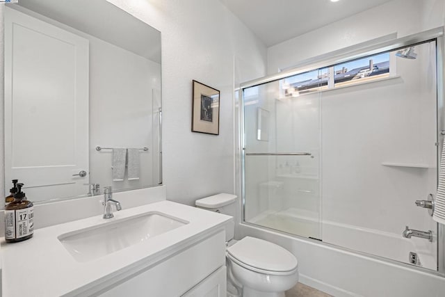 full bathroom featuring vanity, shower / bath combination with glass door, and toilet