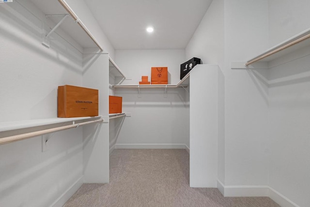 walk in closet featuring light carpet