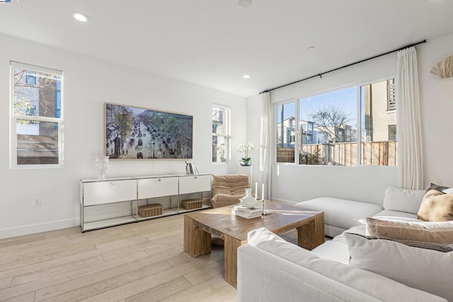 living room with a wealth of natural light and light hardwood / wood-style flooring