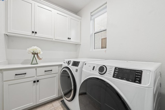 laundry room featuring cabinets, independent washer and dryer, and light tile patterned floors