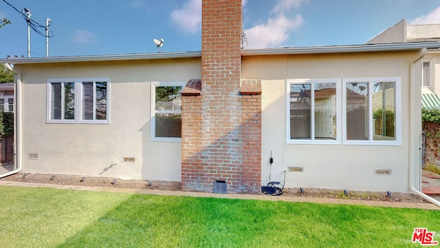 rear view of property featuring a yard