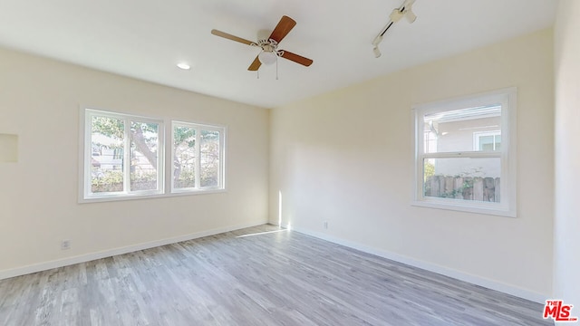 spare room featuring ceiling fan, track lighting, and light hardwood / wood-style flooring