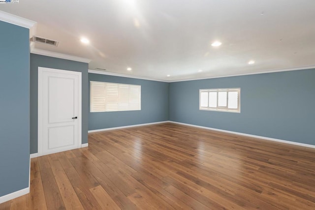 empty room featuring hardwood / wood-style flooring and crown molding