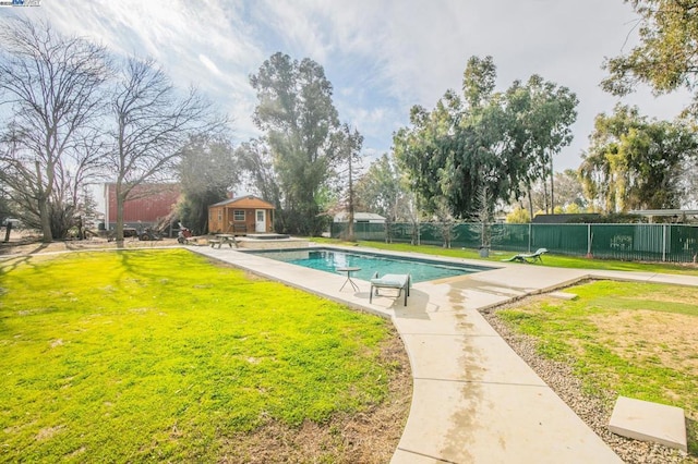 view of swimming pool with a patio, an outdoor structure, and a yard