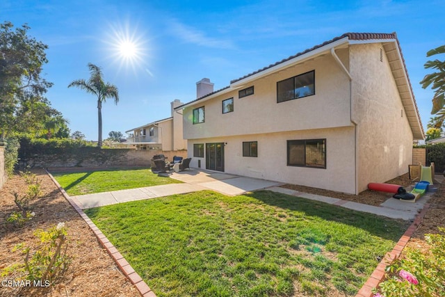 rear view of house with a patio and a yard