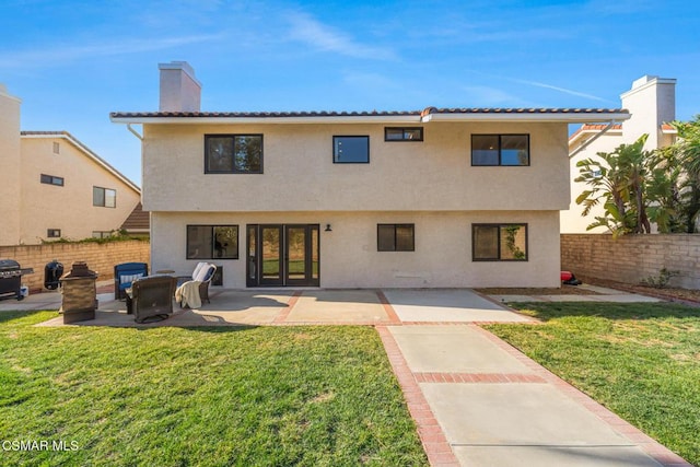 rear view of property with a yard and a patio area