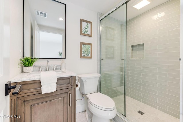 bathroom featuring vanity, toilet, and an enclosed shower