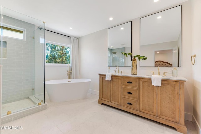 bathroom featuring vanity, separate shower and tub, and a wealth of natural light