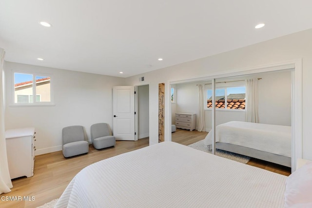 bedroom with multiple windows and light wood-type flooring