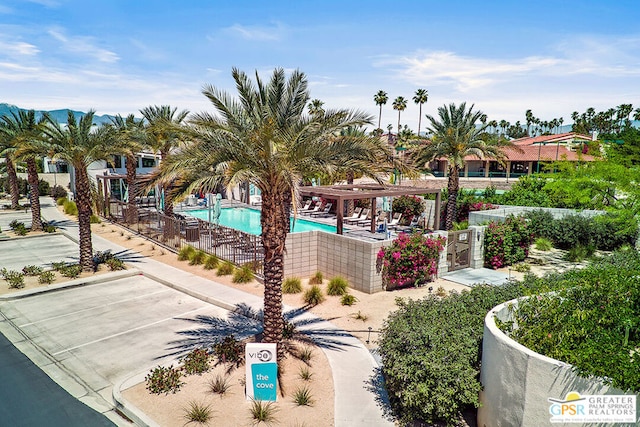 view of home's community featuring a pool and a pergola