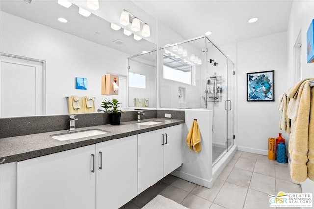 bathroom with walk in shower, vanity, and tile patterned flooring