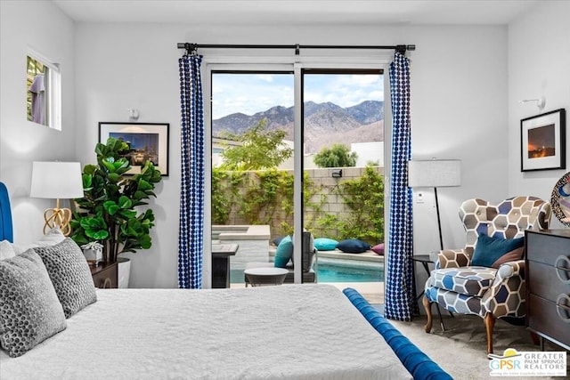 carpeted bedroom featuring a mountain view and access to exterior