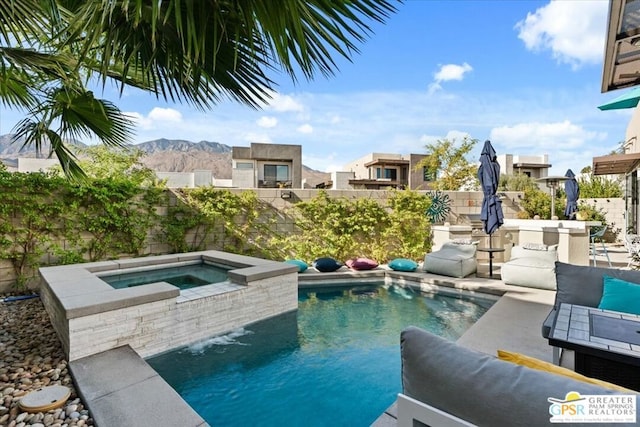 view of pool featuring a mountain view, an outdoor hangout area, and an in ground hot tub