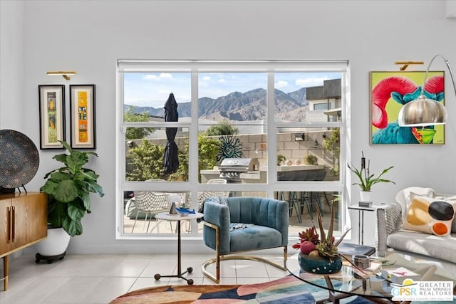 living area featuring light tile patterned flooring, a mountain view, and a wealth of natural light