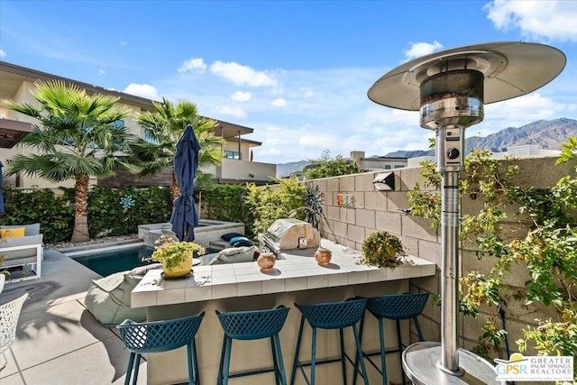 view of patio / terrace with a mountain view, a grill, and a bar