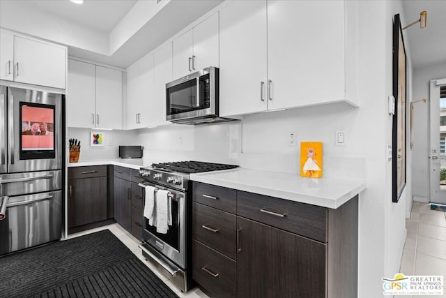 kitchen with white cabinetry, appliances with stainless steel finishes, dark brown cabinets, and light tile patterned floors