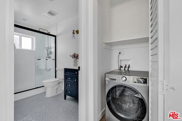 laundry area featuring washer / dryer and light tile patterned floors