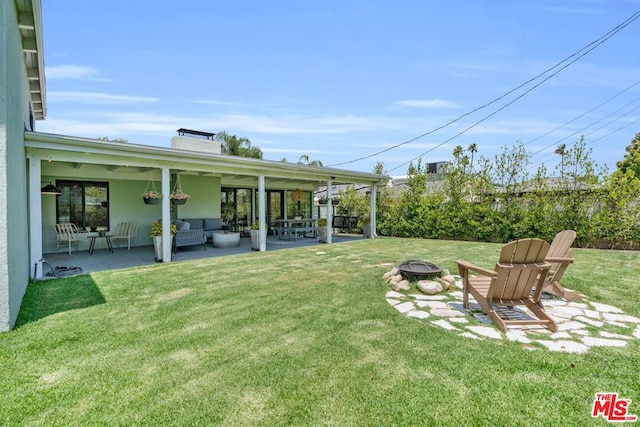 view of yard featuring a patio and an outdoor living space with a fire pit