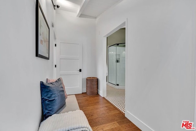 hallway with beam ceiling and light hardwood / wood-style flooring