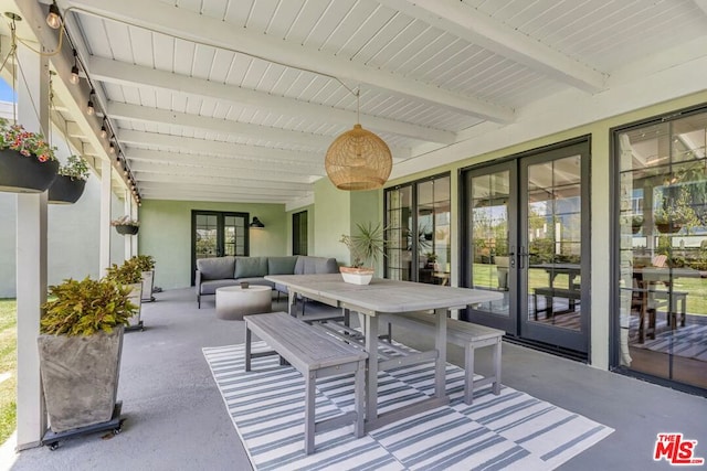 sunroom / solarium featuring french doors and beamed ceiling