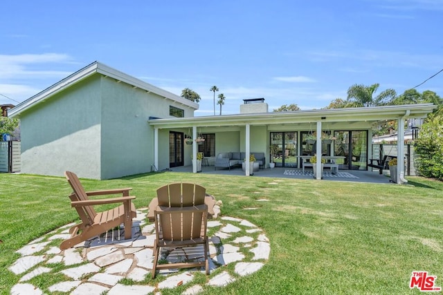 rear view of property with an outdoor hangout area, a patio area, and a lawn