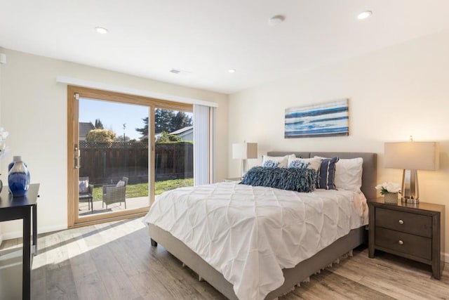 bedroom with access to exterior and light hardwood / wood-style floors