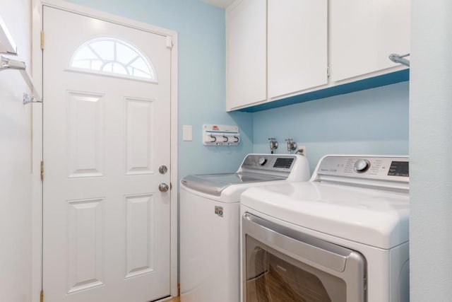 laundry room featuring cabinets and washer and clothes dryer