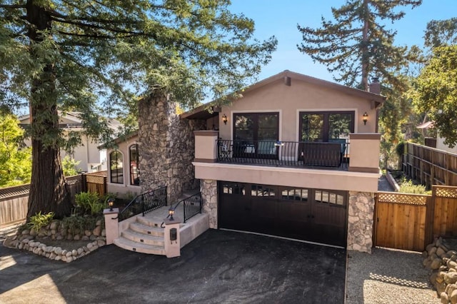 view of front of property featuring a balcony and a garage