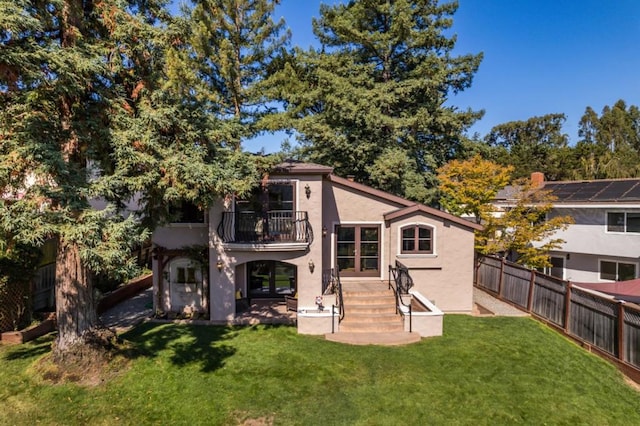 back of house featuring a yard and a balcony