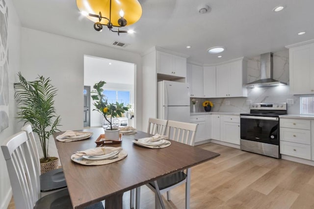 dining space with a chandelier and light hardwood / wood-style flooring