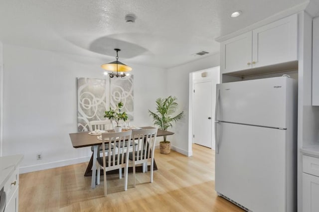 dining space featuring an inviting chandelier and light hardwood / wood-style floors