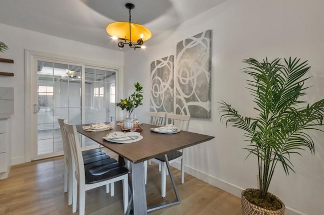 dining space featuring wood-type flooring and a chandelier