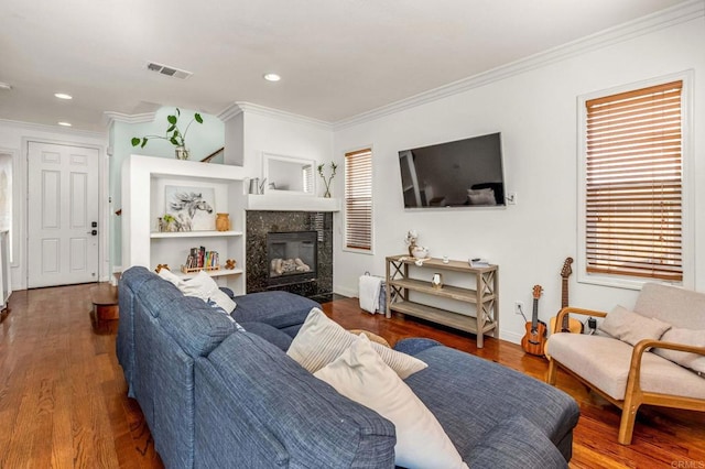 living room featuring a fireplace, crown molding, wood-type flooring, and plenty of natural light