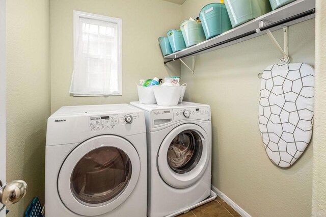 washroom with dark tile patterned flooring and washer and clothes dryer