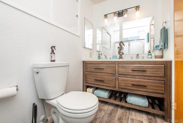 bathroom with hardwood / wood-style flooring, vanity, and toilet