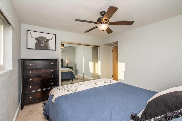 carpeted bedroom with ceiling fan and a closet