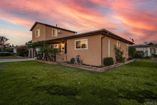 property exterior at dusk featuring a lawn