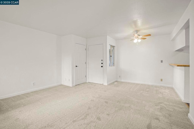 unfurnished living room featuring ceiling fan and light carpet