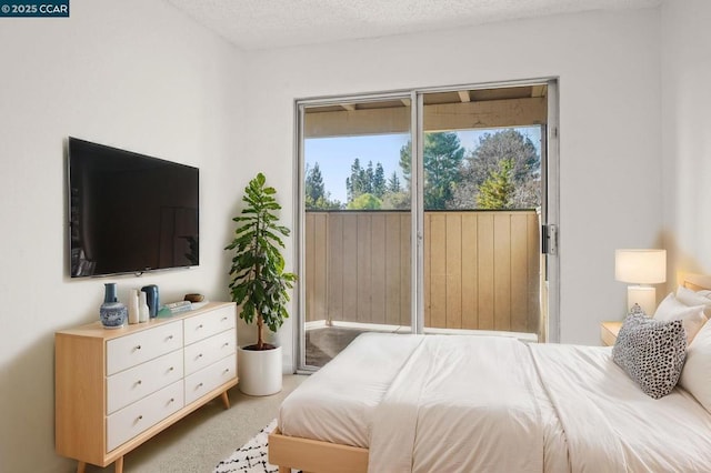 carpeted bedroom featuring access to outside and a textured ceiling