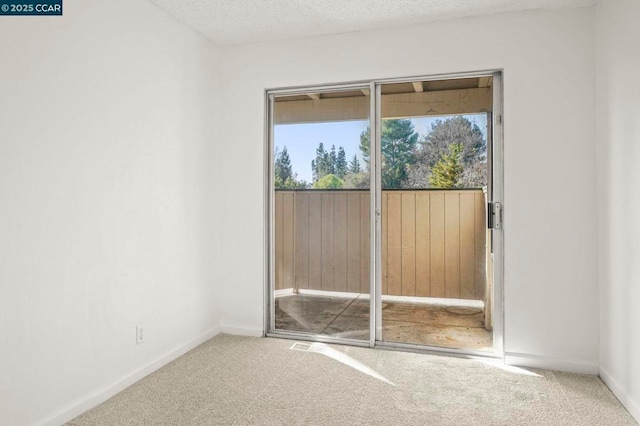 carpeted spare room with a textured ceiling