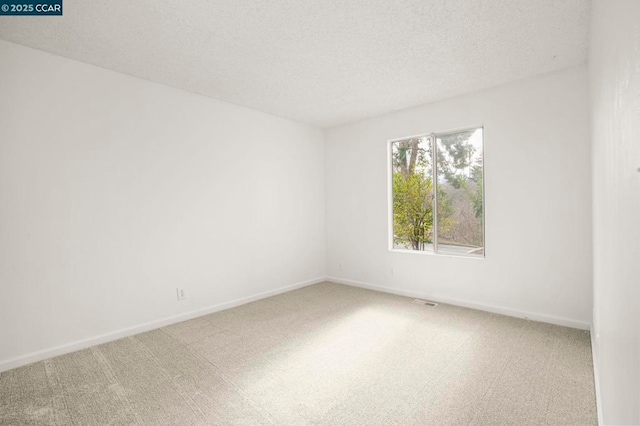 carpeted empty room with a textured ceiling