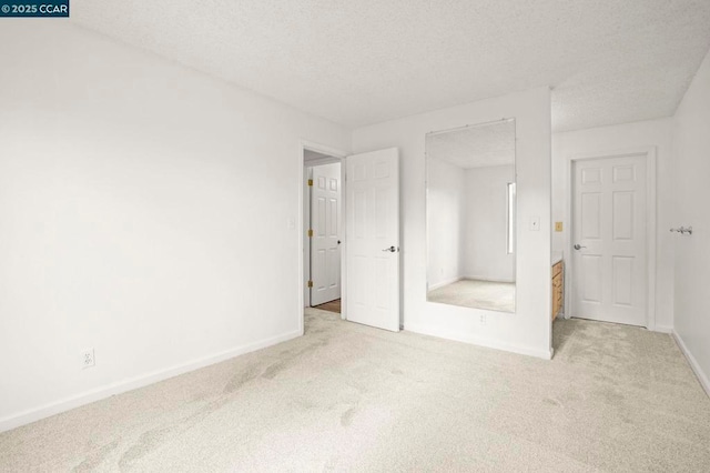 unfurnished bedroom featuring light colored carpet and a textured ceiling