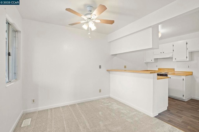 kitchen featuring carpet floors, white cabinets, ceiling fan, and kitchen peninsula