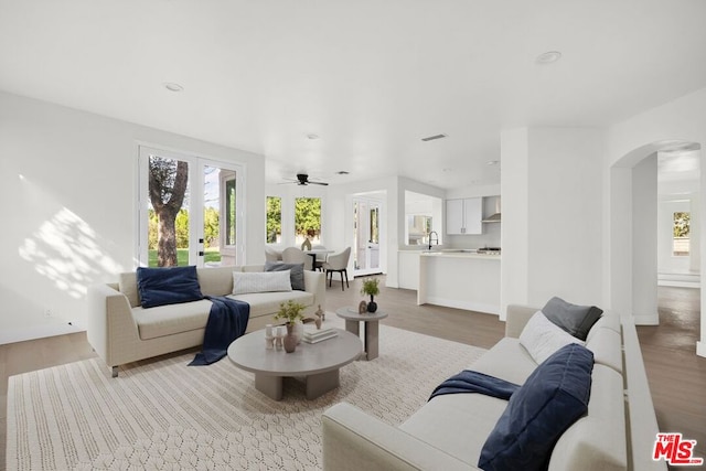 living room with sink, hardwood / wood-style flooring, and ceiling fan