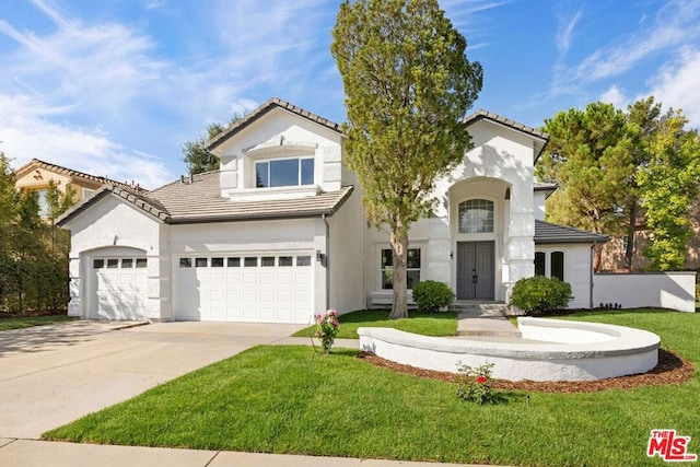 mediterranean / spanish-style house with a garage and a front yard