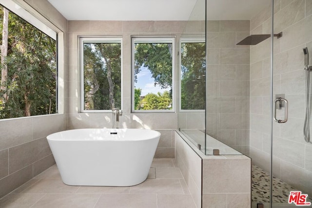 bathroom featuring separate shower and tub, tile patterned flooring, and tile walls